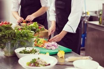 Professional team cooks and chefs preparing meals at busy hotel or restaurant  kitchen. team cooks and chefs preparing meals
