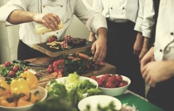 Professional team cooks and chefs preparing meal at busy hotel or restaurant  kitchen. team cooks and chefs preparing meal