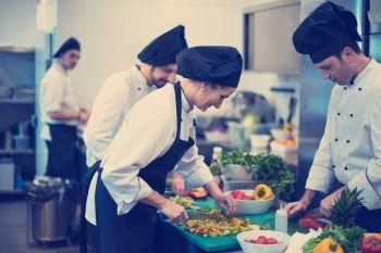 Professional team cooks and chefs preparing meals at busy hotel or restaurant  kitchen. team cooks and chefs preparing meals