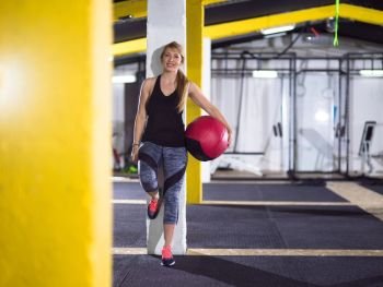 Portrait of beautiful athlete woman with red medicine  ball at crossfitness gym. portrait of woman with red crossfitness ball