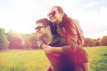 travel, hiking, backpacking, tourism and people concept - happy couple in sunglasses with backpacks having fun and walking along country road outdoors. happy couple with backpacks having fun outdoors