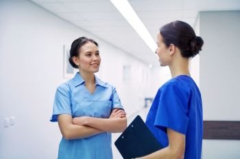 clinic, profession, people, health care and medicine concept -  nurses or doctors talking at hospital. medics, nurses or doctors talking at hospital