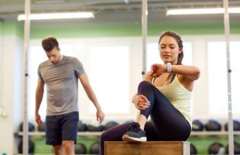 sport, fitness, lifestyle and people concept - man and woman with heart rate tracker in gym. man and woman with heart rate tracker in gym