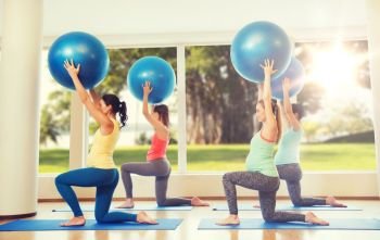 pregnancy, sport, fitness, people and healthy lifestyle concept - group of happy pregnant women exercising with ball in gym over natural window view background. happy pregnant women exercising with ball in gym