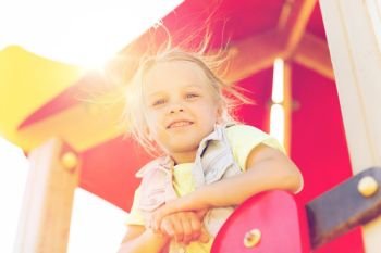 summer, childhood, leisure and people concept - happy little girl on children playground. happy little girl on children playground