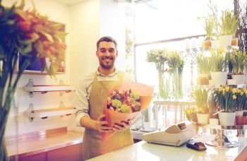 people, business, sale and floristry concept - happy smiling florist man with bunch at flower shop. smiling florist man making bunch at flower shop