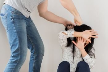 domestic violence, abuse and people concept - man beating helpless woman at home. unhappy woman suffering from domestic violence