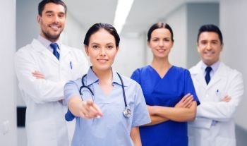 clinic, profession, people, health care and medicine concept - group of happy medics or doctors pointing finger on you at hospital corridor. group of medics pointing finger on you at hospital