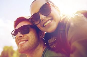 travel, hiking, backpacking, tourism and people concept - happy couple in sunglasses having fun outdoors. happy couple having fun outdoors