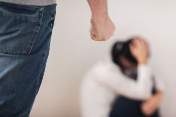 domestic violence, abuse and people concept - man beating helpless woman at home. unhappy woman suffering from domestic violence