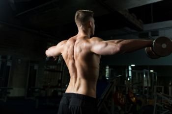 sport, bodybuilding, fitness and people concept - close up of young man with dumbbells flexing muscles in gym. close up of man with dumbbells exercising in gym