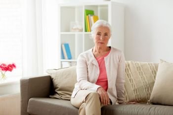 old age and people concept - senior woman sitting on sofa at home. senior woman at home
