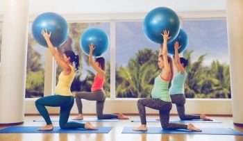 pregnancy, sport, fitness, people and healthy lifestyle concept - group of happy pregnant women exercising with ball in gym. happy pregnant women exercising with ball in gym