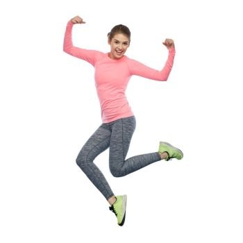 sport, fitness, motion and people concept - happy smiling young woman jumping in air and showing power gesture over white background. happy smiling sporty young woman jumping in air