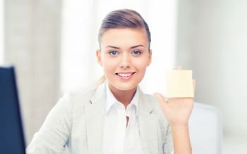 picture of smiling businesswoman showing sticky note. smiling businesswoman showing sticky note