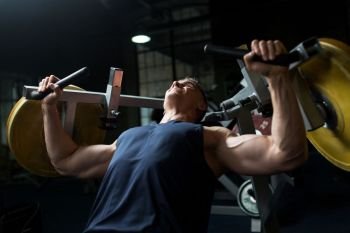 sport, fitness, bodybuilding and people concept - man doing chest press on exercise machine in gym. man doing chest press on exercise machine in gym