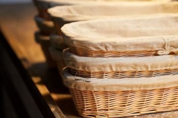 food, cooking and baking concept - bakery wicker baskets on wooden kitchen table. bakery wicker baskets on wooden kitchen table