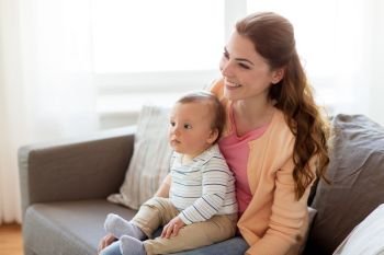 family, child and motherhood concept - happy smiling young mother with little baby at home. happy young mother with little baby at home