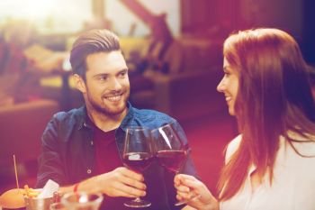 leisure, eating, food and drinks, people and holidays concept - smiling couple having dinner and drinking red wine at restaurant. couple dining and drinking wine at restaurant