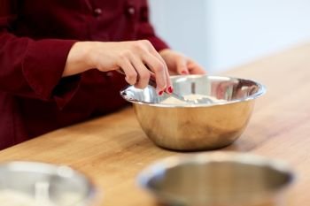 cooking food, baking and people concept - chef with flour in bowl making batter or dough. chef with flour in bowl making batter or dough