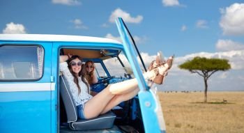 summer holidays, road trip, travel and people concept - smiling young hippie women resting in minivan car over african savannah background. happy hippie women in minivan car in africa