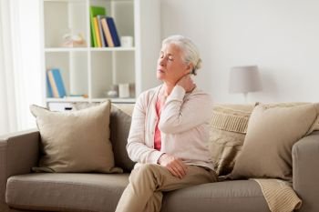old age, health problem and people concept - senior woman suffering from neck pain at home. senior woman suffering from neck pain at home