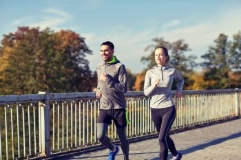fitness, sport, people and lifestyle concept - happy couple running outdoors. happy couple running outdoors