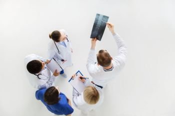 medicine, healthcare and surgery concept - group of doctors or surgeons with spine x-ray and clipboards at hospital. doctors with spine x-ray and clipboards