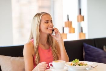 people, communication and leisure concept - happy woman drinking coffee at restaurant and calling on smartphone. woman with coffee calling smartphone at restaurant