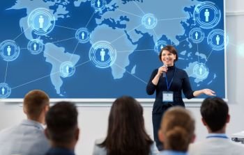 business, global network and people concept - smiling businesswoman or lecturer with world map on projection screen and microphone talking to group of students at conference presentation or lecture. group of people at business conference or lecture