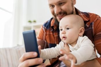 family, parenthood and people concept - happy father with little baby boy taking selfie at home. happy father with baby boy taking selfie at home