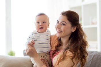 family, child and motherhood concept - happy smiling young mother with little baby at home. happy young mother with little baby at home