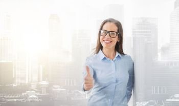 people, business and cooperation concept - happy smiling middle aged woman in glasses showing thumbs up over city buildings background and double exposure effect. happy smiling woman in glasses showing thumbs up
