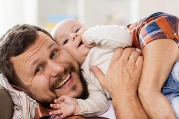 family, parenthood and people concept - close up of happy father with little baby boy at home. close up of happy father with little baby at home