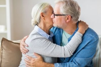 relationships, old age and people concept - close up of happy senior couple hugging and kissing at home. close up of happy senior couple hugging at home