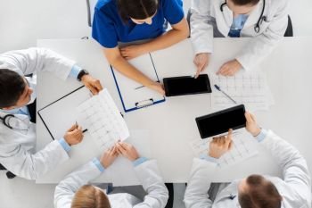 medicine, healthcare and cardiology concept - group of doctors with cardiograms, clipboard and tablet pc computers at hospital. doctors with cardiograms and tablet pc at hospital