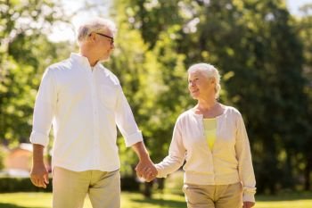 old age, relationship and people concept - happy senior couple walking at summer park. happy senior couple walking at summer park