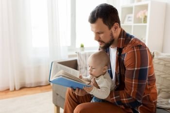 family, parenthood and people concept - happy father and little baby boy with book at home. happy father and little baby boy with book at home