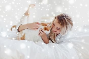 pets, morning, comfort, rest and people concept - happy young woman with cat in bed at home over snow. happy young woman with cat in bed at home