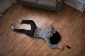 murder, kill and people concept - unconscious or dead woman body and smartphone lying on floor at crime scene (staged photo). dead woman body lying on floor at crime scene