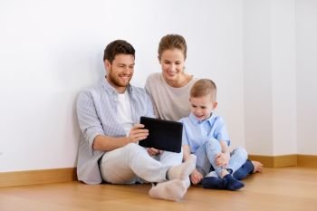mortgage, people, technology and real estate concept - happy family with tablet pc computer moving to new home. happy family with tablet pc moving to new home