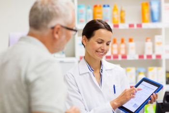 medicine, pharmaceutics, healthcare and technology concept - happy apothecary and senior customer with tablet pc computer at pharmacy. apothecary and customer with tablet pc at pharmacy