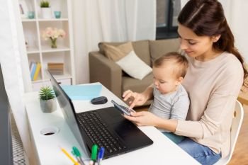 motherhood, multi-tasking, family and people concept - happy mother with baby and laptop working at home. happy mother with baby and laptop working at home