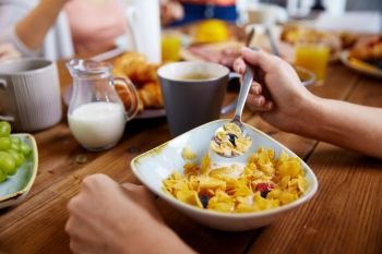 food and people concept - hands of woman eating cereals for breakfast at home. hands of woman eating cereals for breakfast