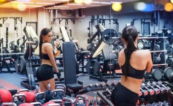 sport, fitness, lifestyle, technology and people concept - young woman with smartphone taking mirror selfie in gym. woman with smartphone taking mirror selfie in gym