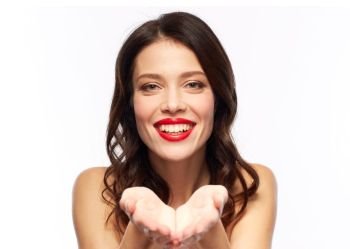 beauty, make up and people concept - happy smiling young woman with red lipstick holding something imaginary on palms over white background. beautiful smiling young woman with red lipstick