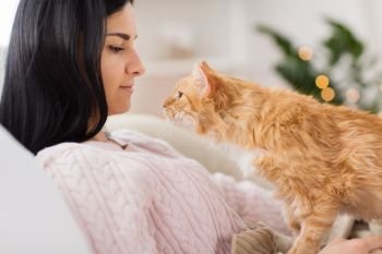 pets, hygge and people concept - close up of female owner with red tabby cat in bed at home. close up of owner with red cat in bed at home