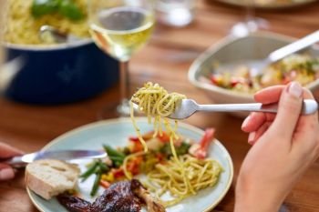 food and people concept - hands of woman with fork and knife eating pasta. hands of woman eating pasta