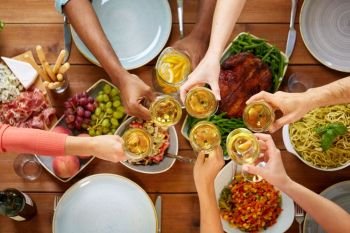 celebration, thanksgiving day, eating and holidays concept - hands clinking wine glasses over table with food. hands clinking wine glasses over table with food