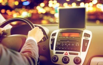 transport, business trip, technology and people concept - close up of businessman with tablet pc computer driving car over night city lights background. close up of young man with tablet pc driving car